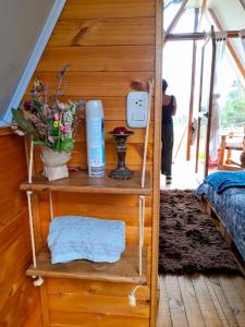 Zimmer mit einem Bett und einem Regal mit Aperitif in der Unterkunft Dante Glamping in Guatavita