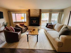 uma sala de estar com um sofá e uma mesa de centro em 2BR 2BA Pine Ridge Condo, Ski In em Breckenridge