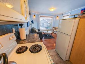 a kitchen with a stove top oven next to a refrigerator at Downtown Whitehorse Apartment in Old Town in Whitehorse