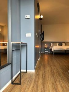 Zimmer mit einem Bett und einem Zimmer mit Holzböden in der Unterkunft VillaFiera, Studio near Fiera Milano at Metro stop in Pero
