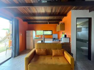 uma sala de estar com um sofá e uma cozinha em Mar de Colores em Punta Del Diablo