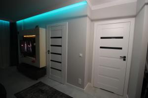 a hallway with a white door with a blue light at Apartament Walendów Park in Walendów