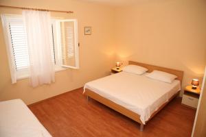 sypialnia z 2 łóżkami i 2 oknami w obiekcie Apartments Radić w Trogirze