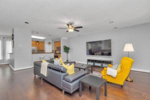 uma sala de estar com um sofá e cadeiras amarelas em Dreamy 3BDRM Museum/Med ctr Gem em Houston
