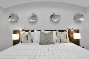 una camera da letto con un letto bianco con cuscini e 2 lampade di Dreamy 3BDRM Museum/Med ctr Gem a Houston