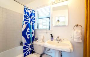 baño con cortina de ducha azul y blanco y lavamanos en Historic Guesthouse 2 Blocks from the U of A, en Tucson