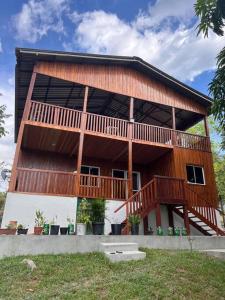 uma grande casa de madeira com um grande deque em Casa Encanto em Manacapuru