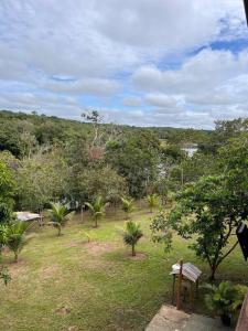 un parque con árboles y un banco en el césped en Casa Encanto en Manacapuru