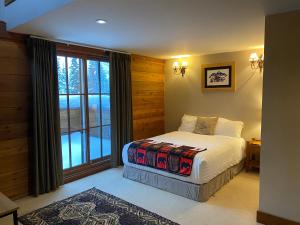 um quarto com uma cama e uma grande janela em Winston Lodge em Golden