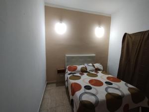 a bedroom with a bed and two lights on the wall at Casa Ana2, a 20 min del aeropuerto de ezeiza in Luis Guillón