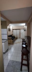 een kamer met een rij krukken en een keuken bij Casa Ana2, a 20 min del aeropuerto de ezeiza in Luis Guillón