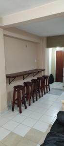 un grupo de mesas y taburetes de madera en una habitación en Casa Ana2, a 20 min del aeropuerto de ezeiza en Luis Guillón
