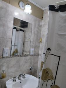 y baño con lavabo y espejo. en Casa Ana2, a 20 min del aeropuerto de ezeiza en Luis Guillón