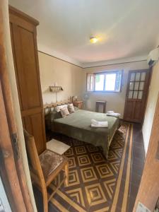 a bedroom with a bed and a chair and a window at B&B La Casa del Padre Leclef in Valle Hermoso