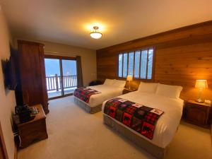 a bedroom with two beds and a balcony at Winston Lodge in Golden