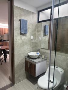 y baño con aseo, lavabo y ducha. en Apartamento Amoblado Pitalito, en Pitalito