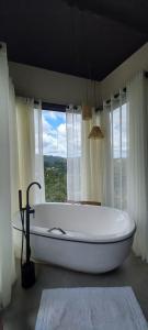 - dużą białą wannę w łazience z oknem w obiekcie Terra de Kurí w mieście Espírito Santo do Pinhal