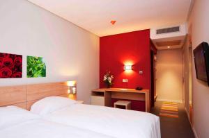 A bed or beds in a room at Manzil Hotel