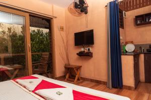 a bedroom with a bed and a tv on the wall at treevillawayanad in Vythiri