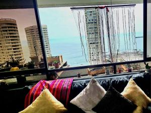 uma sala de estar com um sofá e uma grande janela em Habitación duerme y disfruta junto al mar em Iquique