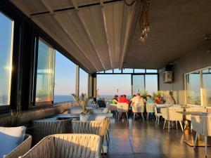 restauracja z ludźmi siedzącymi przy stolikach i oknach w obiekcie Hotel Cosmos w mieście Eforie Sud