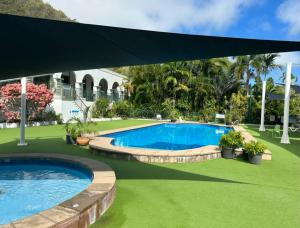 a swimming pool with a canopy over it at Magnetic Island Resort Studio in Nelly Bay