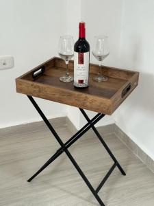 a wooden table with two glasses and a bottle of wine at Apartamento Amoblado Pitalito in Pitalito