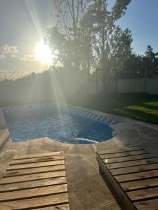 einen Pool im Garten mit Sonne im Hintergrund in der Unterkunft Las Emes in Suipacha