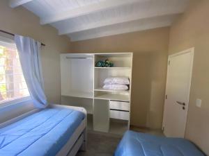 een kleine slaapkamer met een bed en een raam bij BOSQUE LIBERTAD Casa PB in Mar Azul