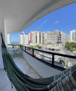 - un hamac sur un balcon avec vue sur la ville dans l'établissement NA PRAIA DE ITAPARICA 2, à Vila Velha