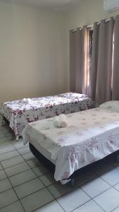 two beds in a room with flowers on them at Residencial Mirandinha in Boa Vista