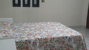 a bed with a floral comforter in a bedroom at Residencial Mirandinha in Boa Vista
