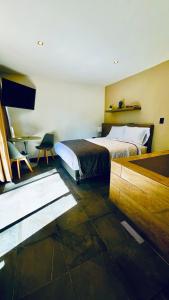 a bedroom with two beds and a desk in it at Roots Luxury Cabins in Mineral del Monte
