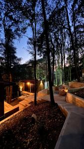 a park with trees and a building with lights at Roots Luxury Cabins in Mineral del Monte