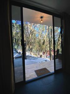 a sliding glass door in a house with a patio at Roots Luxury Cabins in Mineral del Monte