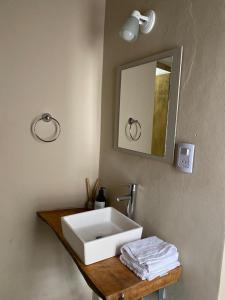 y baño con lavabo blanco y espejo. en EL TOPON cabañas en Albardón