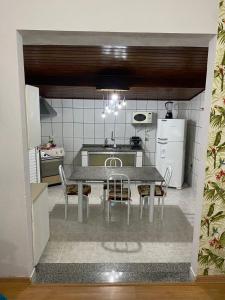 uma cozinha com mesa e cadeiras num quarto em Chácara Serra Negra em Serra Negra