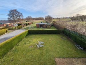 a view of a garden with a bench in the grass at Haus Dorfschmiede, Whg Seestern in Alkersum