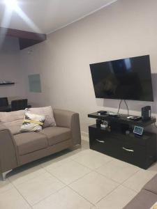 sala de estar con sofá y TV de pantalla plana en Casa llena de vida y buena vibra con las amenidades necesarias para que pases una estancia de 10!, en Colima