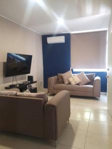 sala de estar con 2 sofás y TV en Casa llena de vida y buena vibra con las amenidades necesarias para que pases una estancia de 10!, en Colima