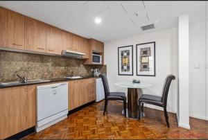a kitchen with a table and two chairs and a sink at Darling Harbour Apartments in Sydney