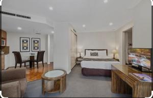 a hotel room with a bed and a living room at Darling Harbour Apartments in Sydney