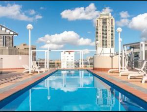 a swimming pool on the roof of a building at Darling Harbour Apartments in Sydney
