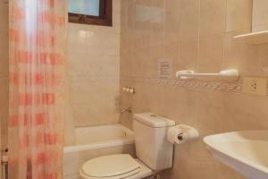 a bathroom with a toilet and a tub and a sink at Apart Vitraux in Las Gaviotas +10 photos