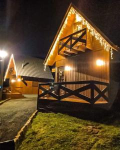uma casa de madeira com uma cerca em frente à noite em Chalés Altos Da Montanha- Everest em Bom Jardim da Serra
