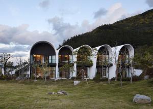 un edificio con tres cúpulas con árboles delante de él en KOSMOS Ulleungdo, en Ullŭng