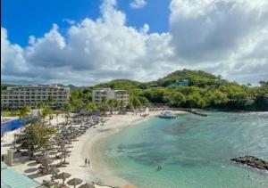 - une plage avec des chaises longues et des parasols dans l'établissement Beachfront Cozy Apt, à Gros Islet