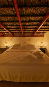 a bedroom with a large white bed with two night stands at Tritón Hotel Boutique & Restaurant in Guayacanes