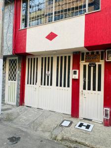 ein rot-weißes Gebäude mit zwei weißen Türen in der Unterkunft Hostel Bogotá Kings in Bogotá