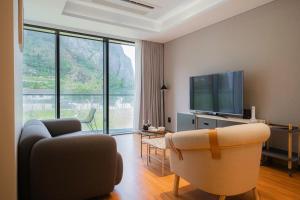uma sala de estar com 2 cadeiras e uma televisão de ecrã plano em Healing Stay KOSMOS em Ullŭng
